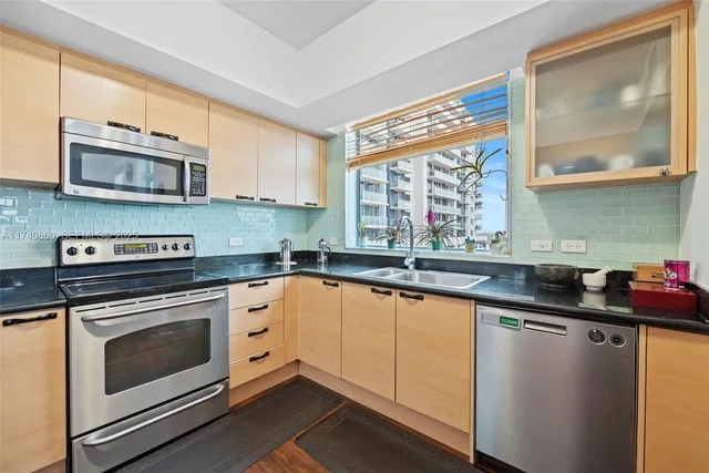 a kitchen with stainless steel appliances granite countertop a stove a sink and a microwave