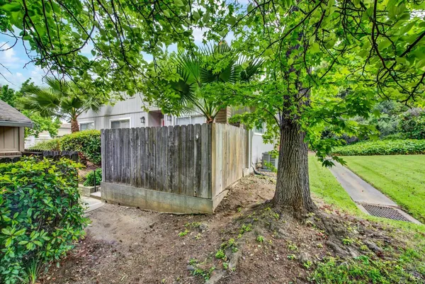 a view of a house with backyard and wooden fence