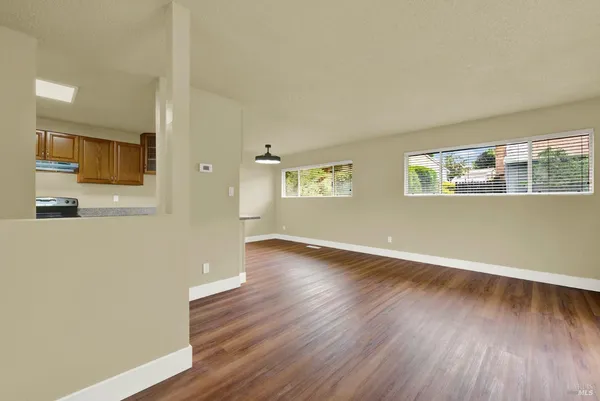 a view of empty room with wooden floor and windows