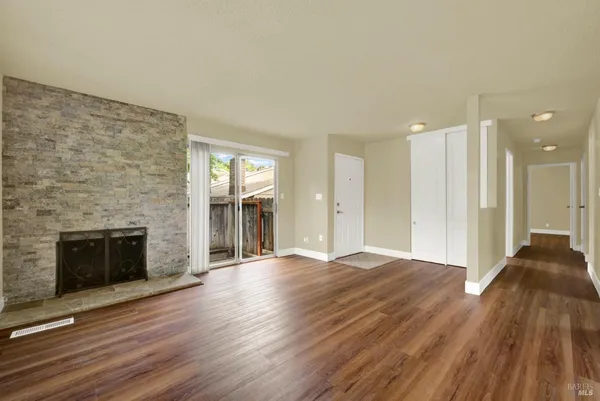 a view of a kitchen with kitchen island a sink wooden floor and a large window