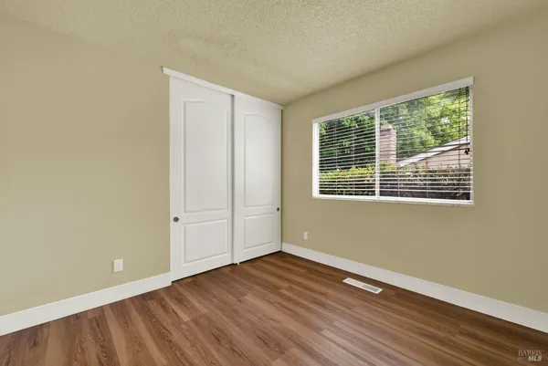 a view of an empty room with wooden floor