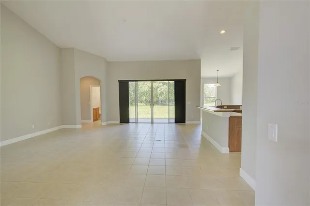 a kitchen with stainless steel appliances granite countertop a sink a stove a refrigerator a washer and dryer with wooden floor