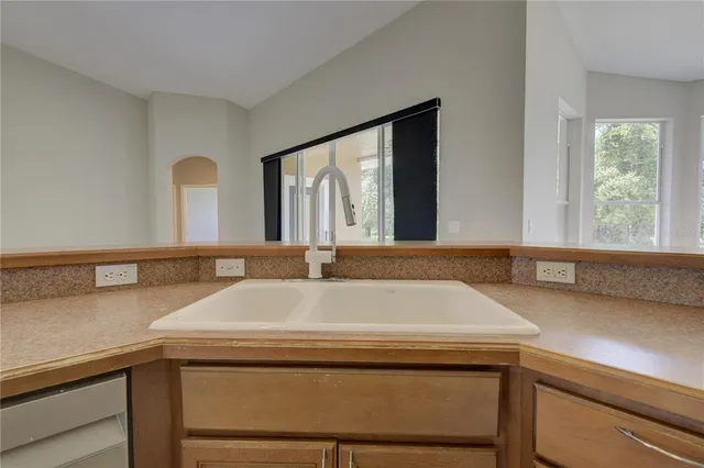 a view of a electric appliances in kitchen and empty room with wooden floor