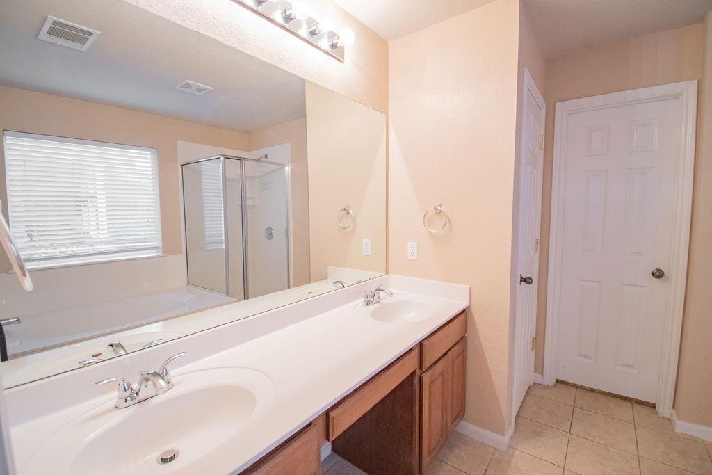312 Pheasant Ridge Drive Round Rock, TX 78665 - Photo 21 of 34 A generous double vanity offers ample counter space, perfectly complementing the adjacent soaking tub and walk-in shower.