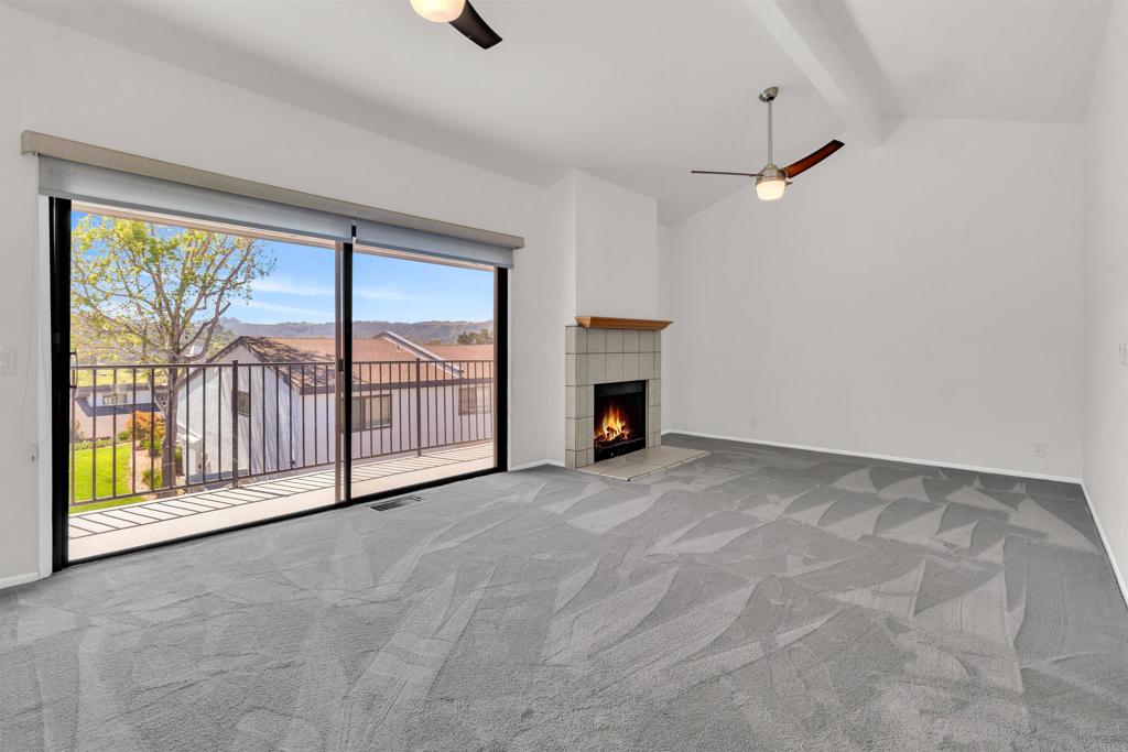 7321 Alicante Road, Unit A Carlsbad, CA 92009 - Photo 8 of 27 an empty room with fireplace and windows
