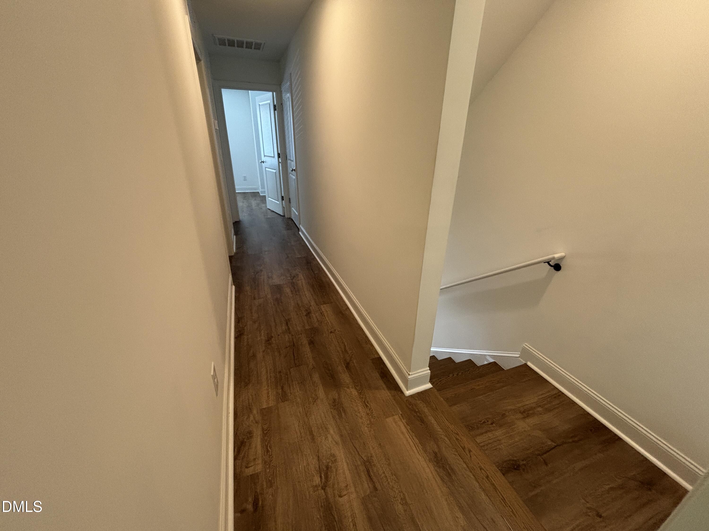 5710 Parker Pnes Court Raleigh, NC 27609 - Photo 52 of 78 a view of a hallway with wooden floor and staircase