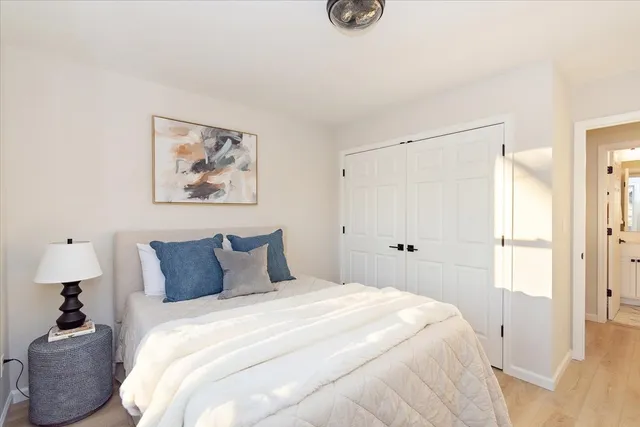 a bedroom with a bed and a painting on the wall