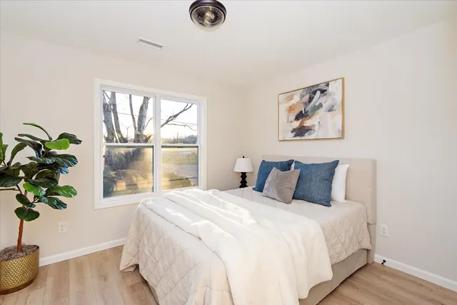 a bedroom with a large bed and a potted plant