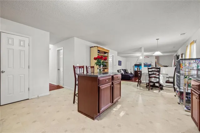 a living room with furniture and a refrigerator