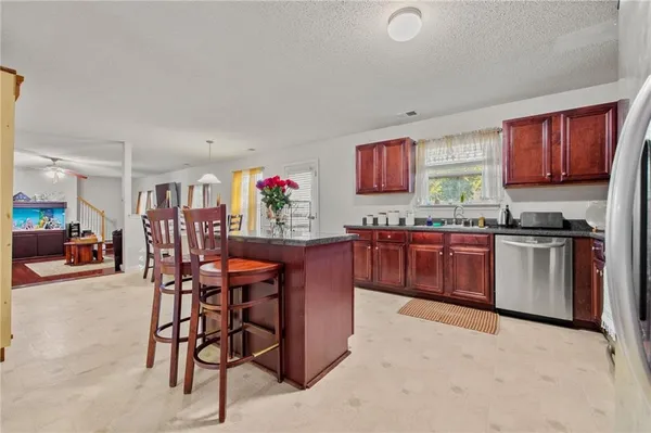 a kitchen with stainless steel appliances kitchen island granite countertop a sink and cabinets
