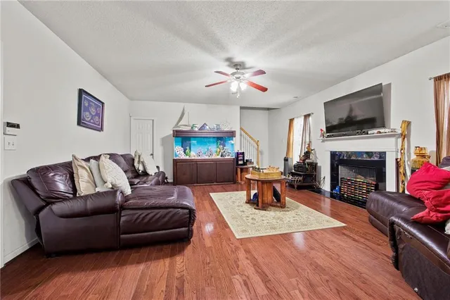 a living room with furniture a flat screen tv and a fireplace