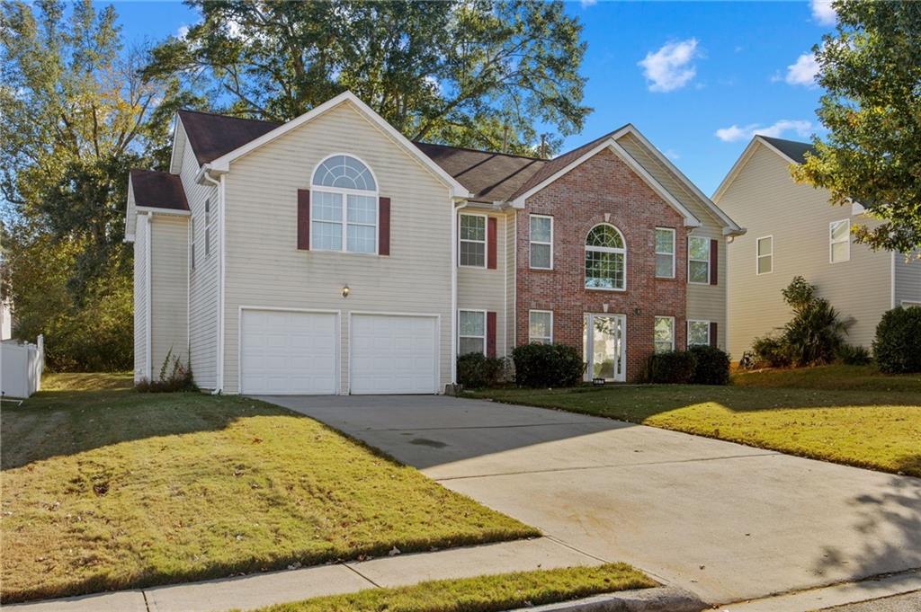 407 Grier Drive Locust Grove, GA 30248 - Photo 2 of 38 a front view of a house with a yard and garage