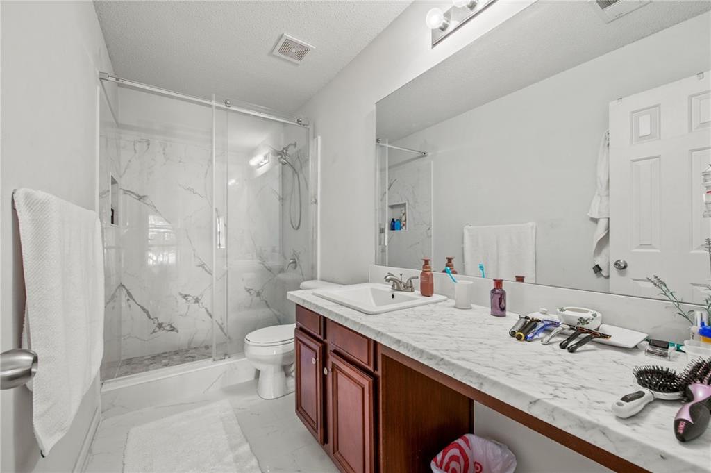 407 Grier Drive Locust Grove, GA 30248 - Photo 32 of 38 a bathroom with a sink toilet double vanity and shower