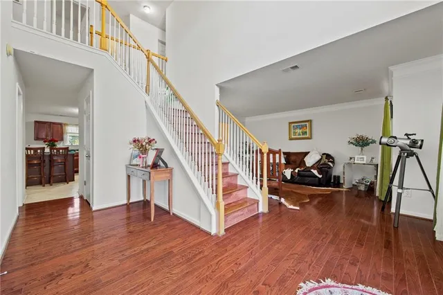 a view of a livingroom with wooden floor and stairs