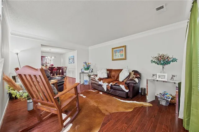 a living room with furniture a wooden floor and a book shelf