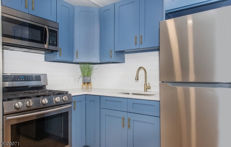 25 Henry Street, Unit 2 Bloomfield, NJ 07003 - Photo 3 of 7 a kitchen with stainless steel appliances a refrigerator stove and microwave