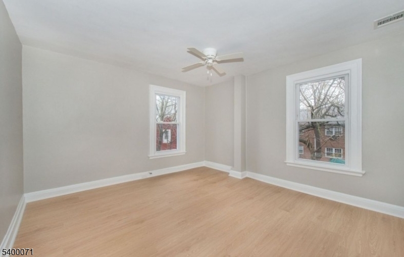 25 Henry Street, Unit 2 Bloomfield, NJ 07003 - Photo 5 of 7 an empty room with windows and ceiling fan view