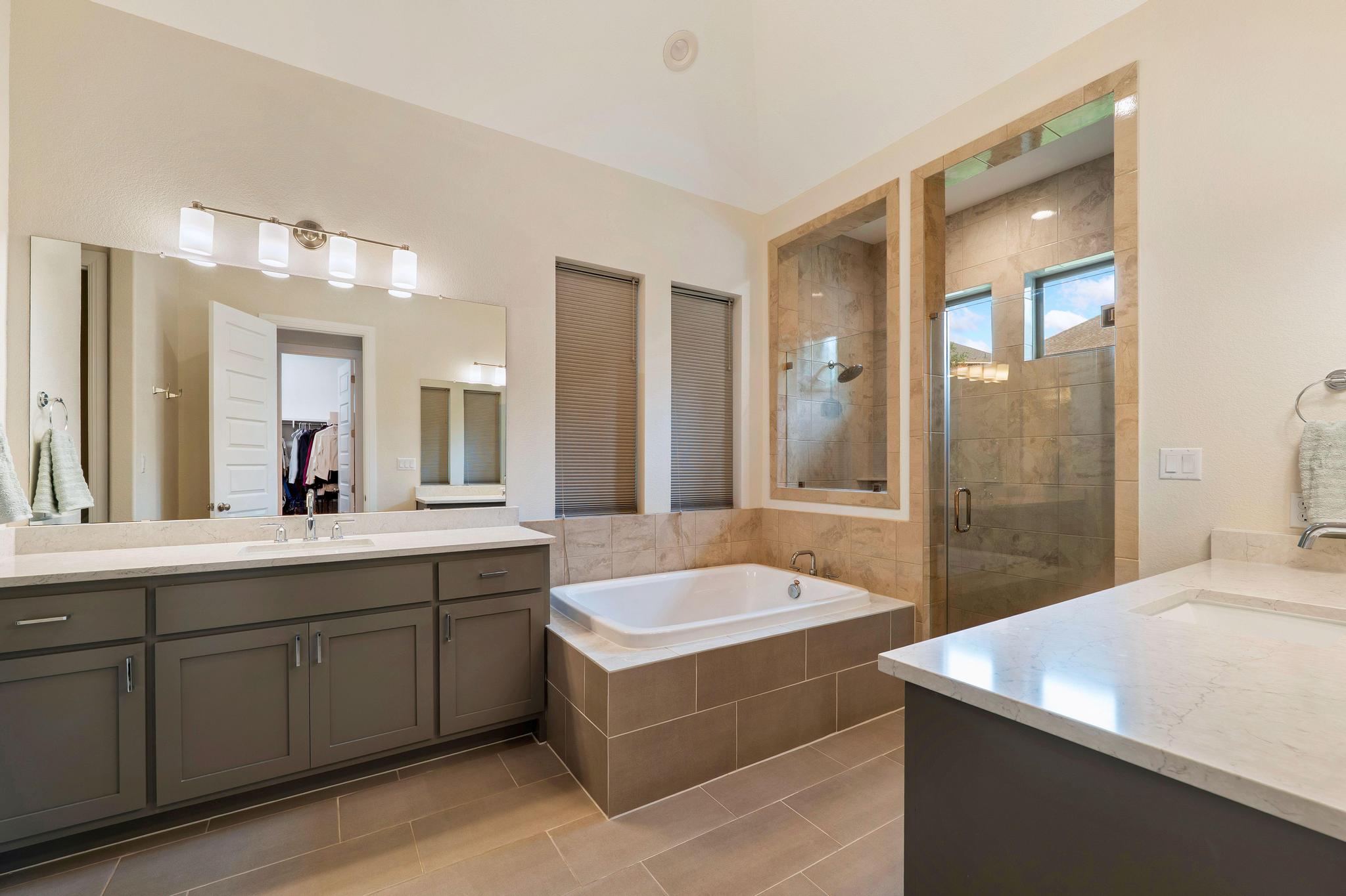 1009 Legacy Crossing Georgetown, TX 78628 - Photo 26 of 40 Luxurious primary bath with dual vanities, soaking tub, and a separate glass-enclosed shower.
