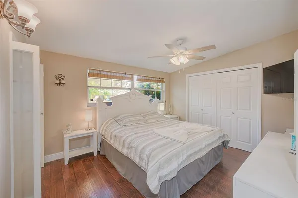a bedroom with a large bed chandelier and a window