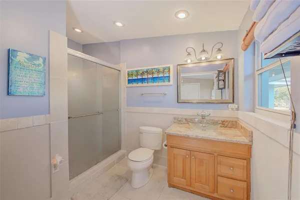a bathroom with a granite countertop sink toilet and mirror