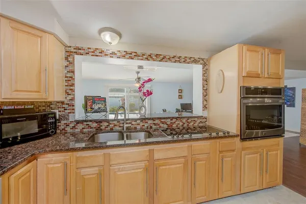 a kitchen with stainless steel appliances granite countertop a sink stove and cabinets