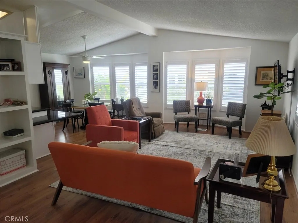 a living room with furniture wooden floor and a large window