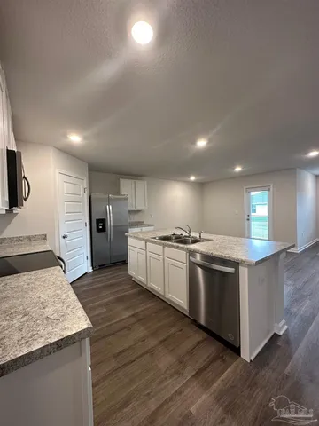 a large kitchen with stainless steel appliances kitchen island a large counter top and a stove