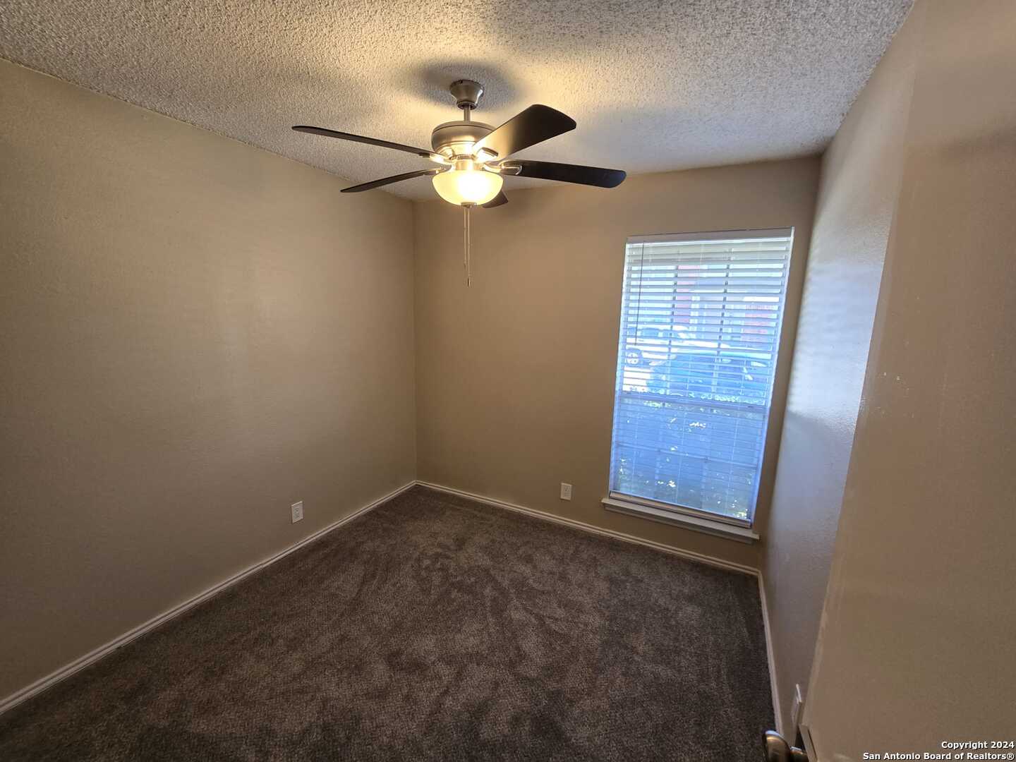 9140 Timber Path, Unit 2702 San Antonio, TX 78250 - Photo 13 of 22 an empty room with windows and fan