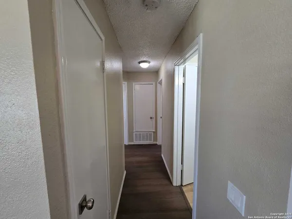 a view of a hallway with wooden floor