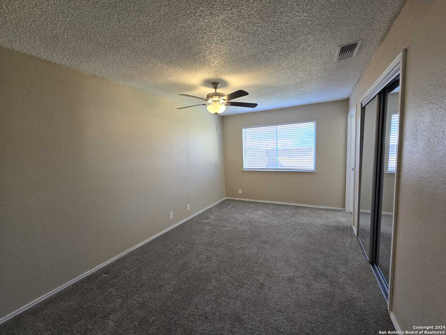 9140 Timber Path, Unit 2702 San Antonio, TX 78250 - Photo 8 of 22 a view of a livingroom with a ceiling fan and window