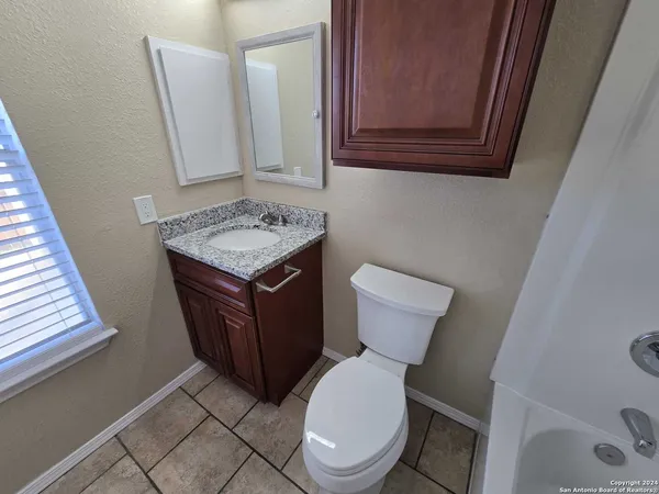 a bathroom with a toilet a sink and a mirror