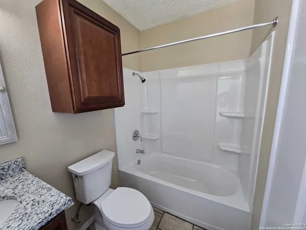 a white toilet sitting next to a bath tub