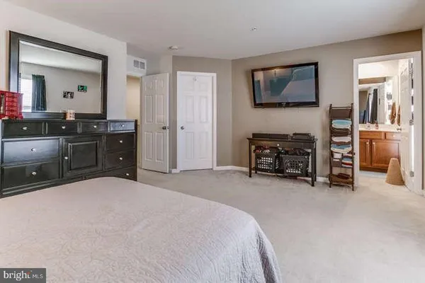 a large bedroom with a bed and furniture