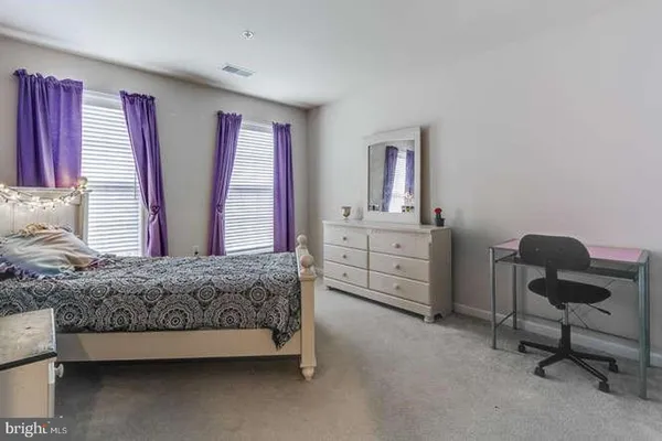 a spacious bedroom with a bed and a cabinets