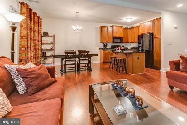 a living room filled with furniture and kitchen view