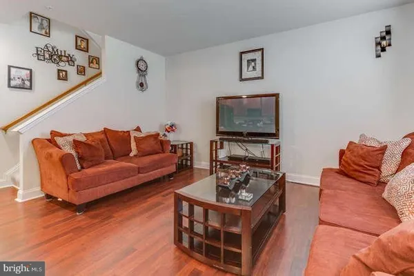 a living room with furniture a flat screen tv and a couch