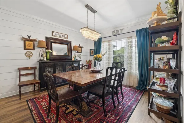 a view of a dining room with furniture a rug and wooden floor