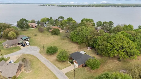 an aerial view of a house with a yard and lake view