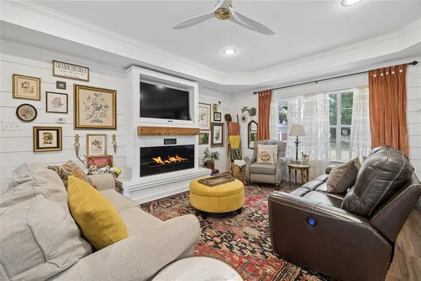 a living room with furniture a flat screen tv and a fireplace