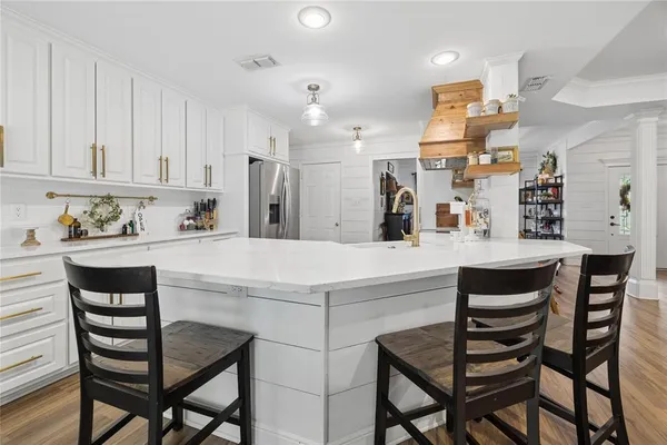 a kitchen with a dining table chairs cabinets and stainless steel appliances