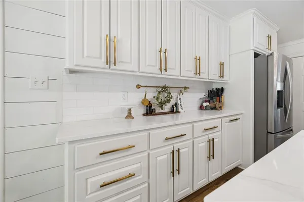 a kitchen with white cabinets and a refrigerator