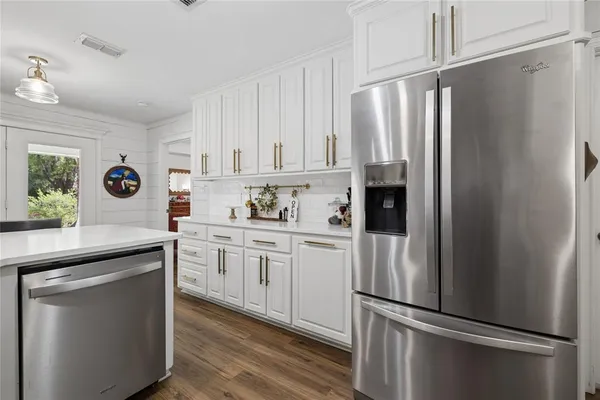 a kitchen with stainless steel appliances a refrigerator sink and cabinets