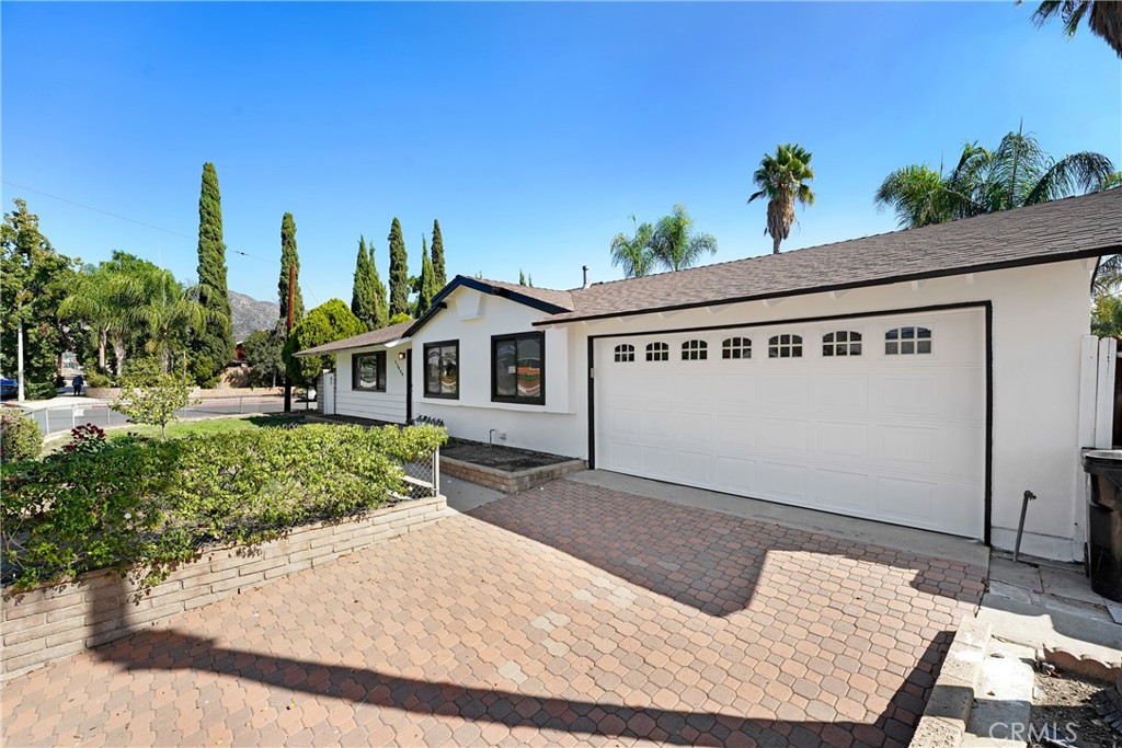 a backyard of a house with table and chairs plants