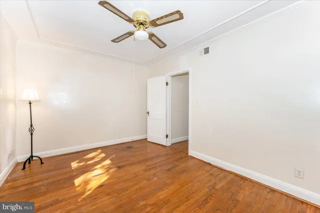 a view of a room with wooden floor and a ceiling fan