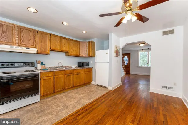 a kitchen with a sink a refrigerator and cabinets