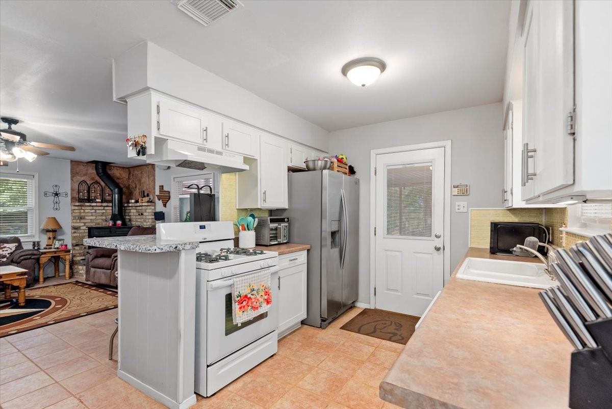 1651 Fultz Court Conroe, TX 77304 - Photo 15 of 38 a open kitchen with stainless steel appliances granite countertop a stove and a refrigerator
