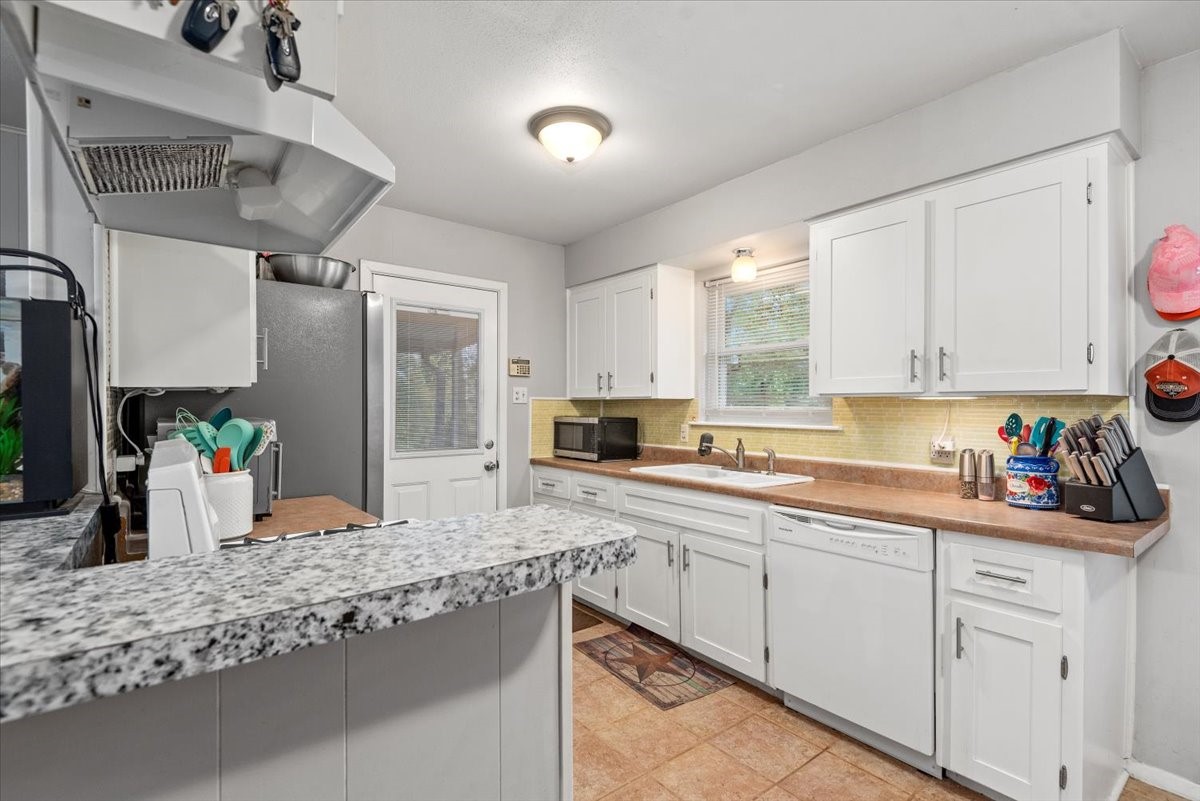 1651 Fultz Court Conroe, TX 77304 - Photo 16 of 38 a kitchen with stainless steel appliances granite countertop a sink window and cabinets