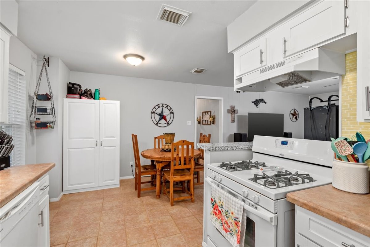 1651 Fultz Court Conroe, TX 77304 - Photo 20 of 38 a kitchen with a stove and white cabinets