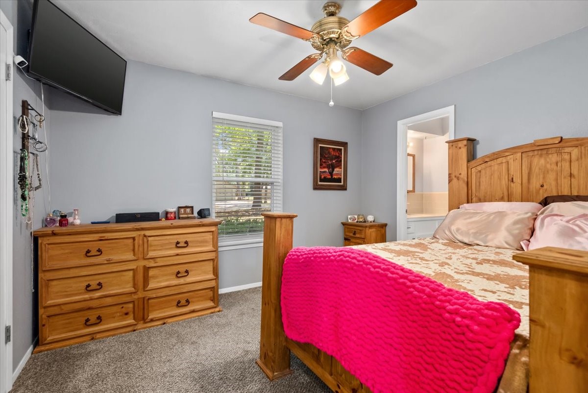 1651 Fultz Court Conroe, TX 77304 - Photo 22 of 38 a bedroom with a bed and a flat screen tv