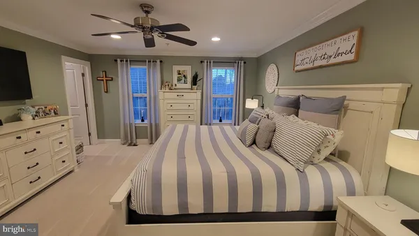 a bedroom with a large bed a flat tv screen and dresser